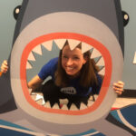 Headshot of Melanie holding up a shark cutout